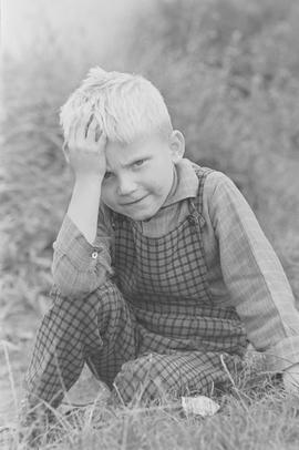 Chłopiec siedzący na trawie